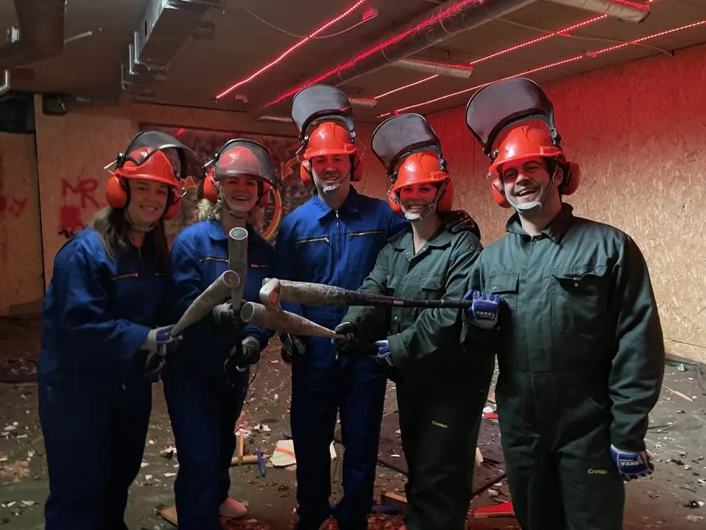 Vijf vrienden lachen en poseren in de Rage Room Eindhoven