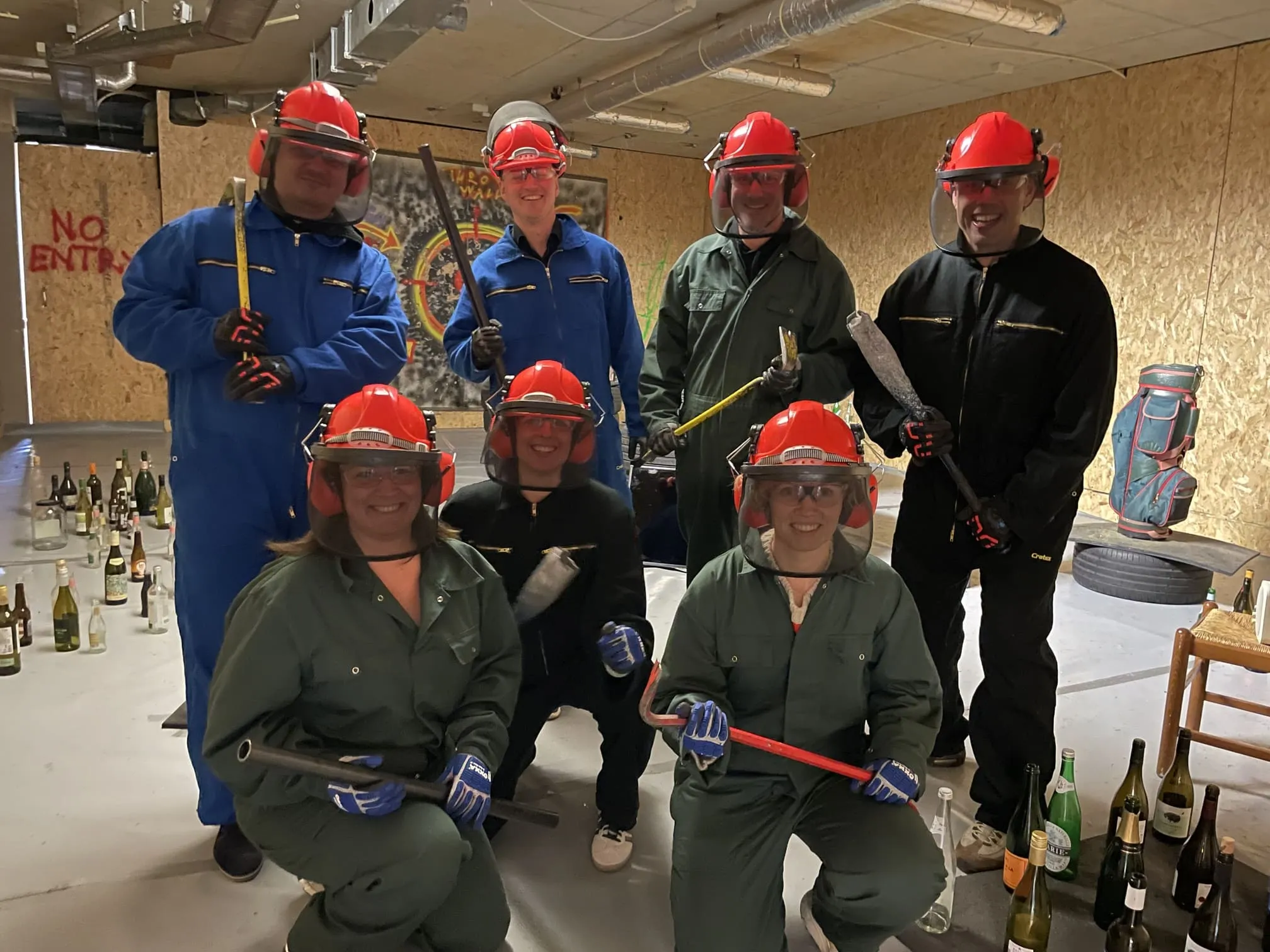 Groep rage room-gasten glimlachend en poserend in uitrusting