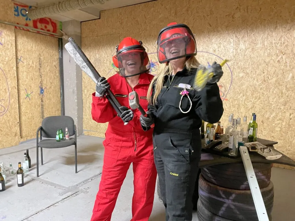 Twee vrouwen in veiligheidsuitrusting voor ragekamer lachen zij aan zij